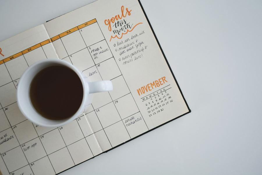 A planner and a cup of coffee on a desk